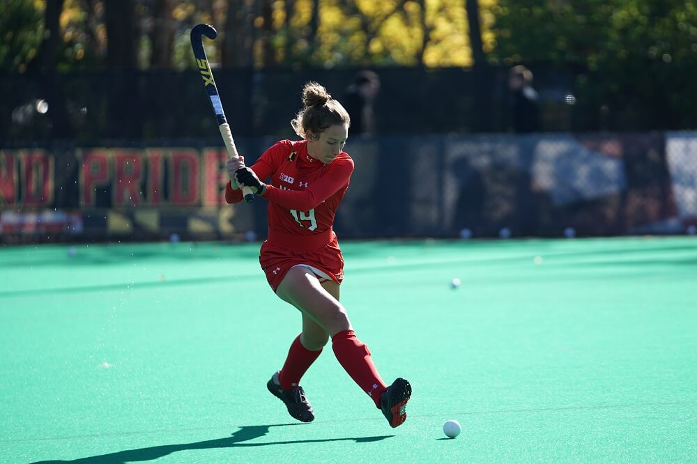 a sports photography shot of a field hockey player about to strike the ball