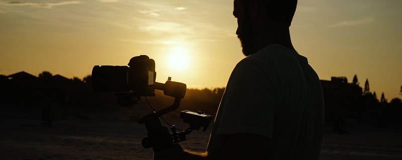 man holding a camera during golden hour