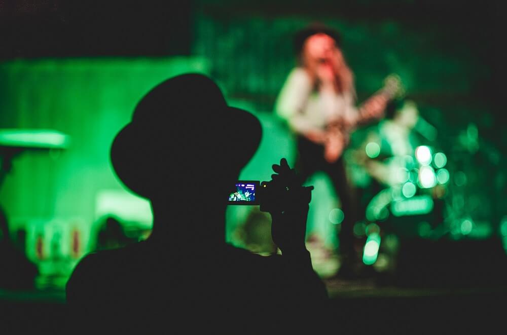 A guy on a concert taking a video