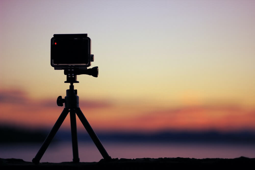 A video camera on tripod recording the sunset