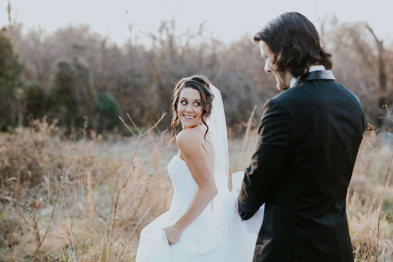 a romantic wedding photo of the bride happily looking at the groom