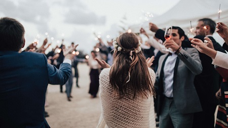 a wedding photo of people toasting for the newly weds