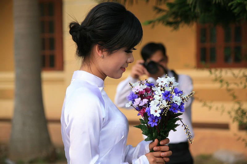 a wedding photo of a vietnamese bride holding a bouquet of flowers