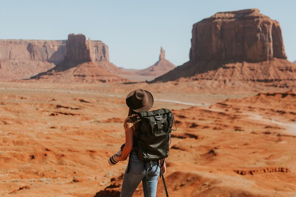 Woman with a backpack in the middle of a desert