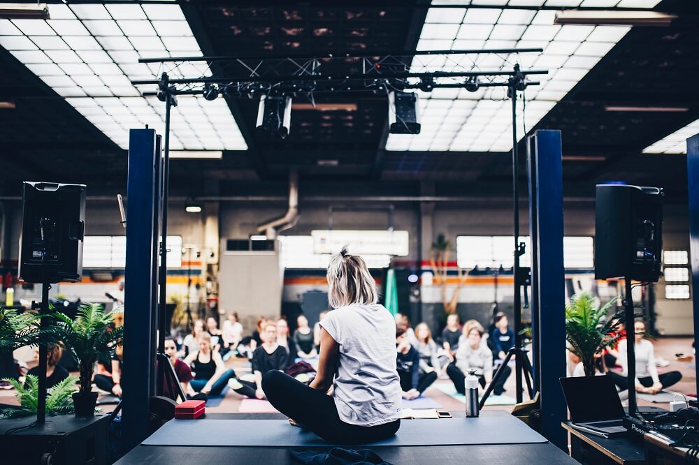 A woman on stage during a yoga event