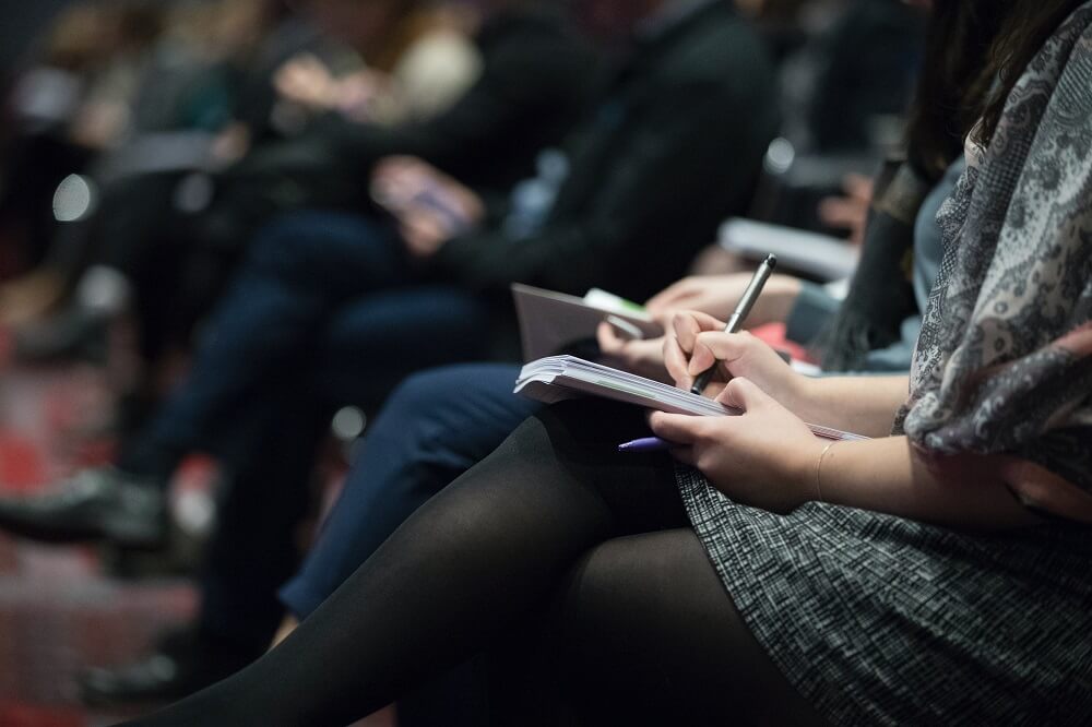 A woman writing on a paper during an event