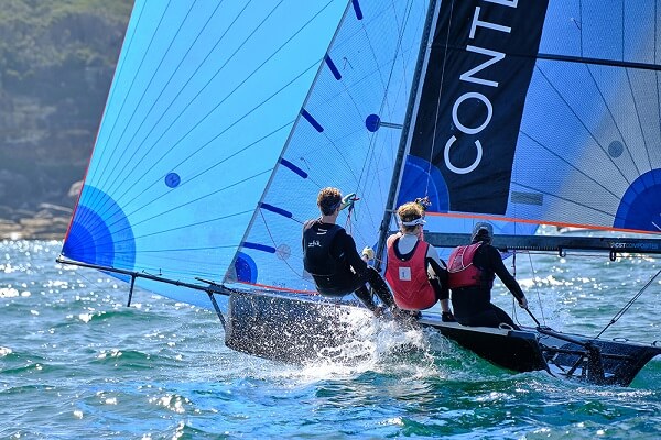 Three men sailing a blue-sailed boat, photographed with the Fujifilm XF 70-300mm f4-5.6 R LM OIS WR lens